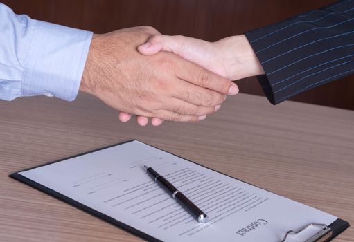 businessman and businesswoman shaking hands to congratulate to be working well.