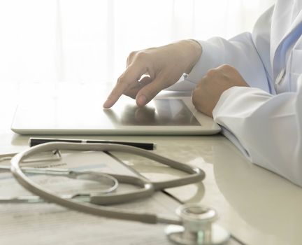 male doctor using digital tablet at work