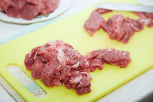 Raw meat sliced on a kitchen table. Close-up view