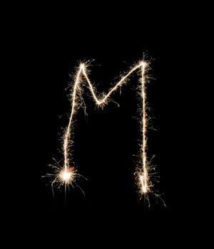 Letter M drew with spakrs on a black background.