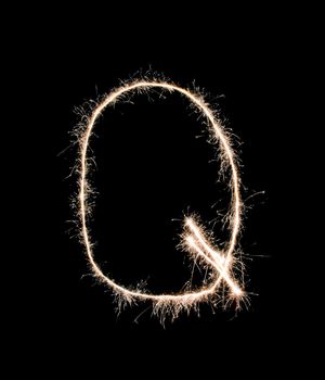 Letter Q drew with spakrs on a black background.
