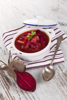 Delicious ukrainian borsch soup on white wooden background. Culinary food eating. 