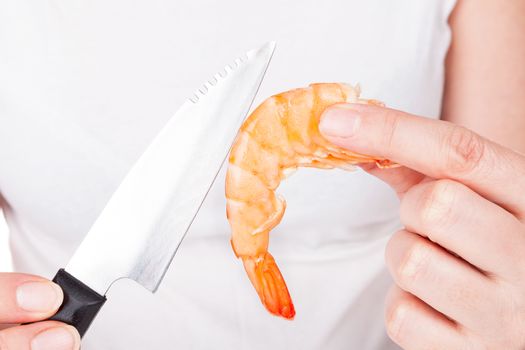 Chef with knife preparing a shrimp. Luxurious seafood cooking, culinary gastronomy.