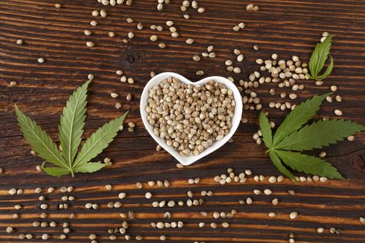 Hemp seeds on wooden background, top view. Cannabis and hemp. 