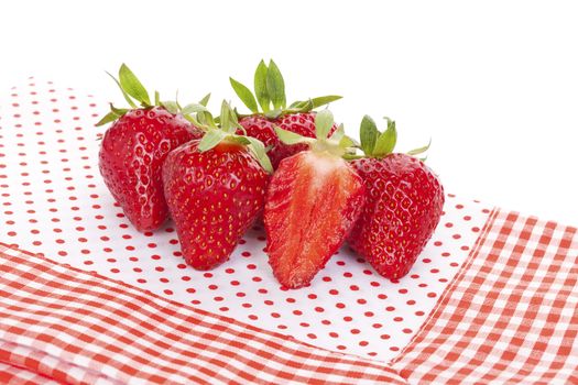 Delicious ripe strawberries on red and white dotted background. Healthy fruit eating.