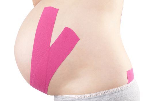 Beautiful pregnant woman with kinesio tape. Back pain in pregnancy, alternative kinesio tape therapy.