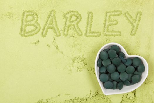 Green food supplement. Word barley written in green ground powder, top view. Healthy lifestyle.