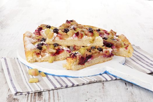 Traditional rhubarb cake on white cutting board isolated on white background. Culinary sweet dessert eating. 