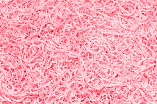 Tinted textured background from the scattered macaroni, pink