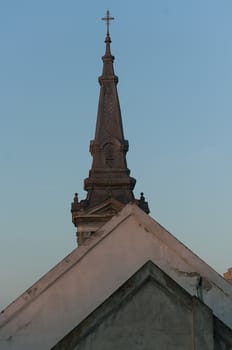 Old roof tops and a steeple of a catholic church. Shapes.