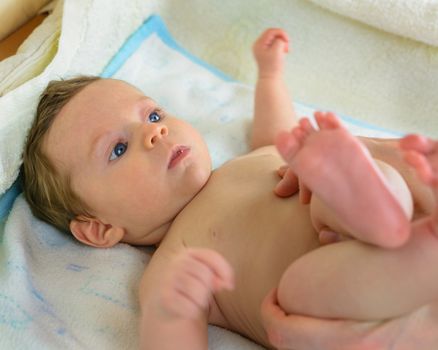 A Infant lying on a towel view mom while making massage