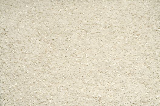 Textured background of rice grains scattered on the surface