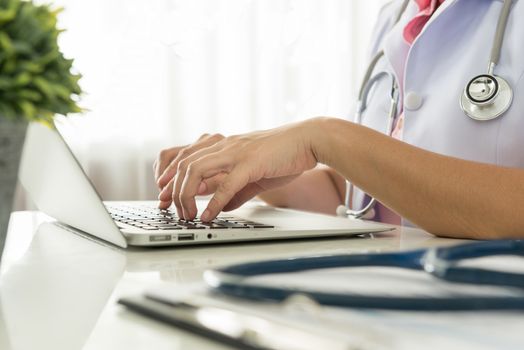 Close-up of a doctor typing on keybord in the office