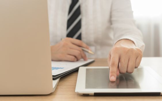 close up businessman's fingers touching the screen tablet computer.