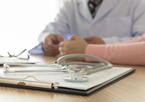 stethoscope and medical documentation  with doctor and patient background