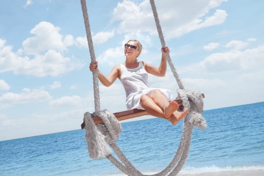 View of nice tropical  beach  with  girl on swing