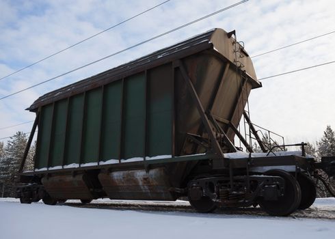 The last car of a freight train on the background of white snow.