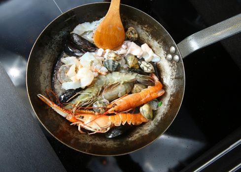 Seafood for paella fried in a pan