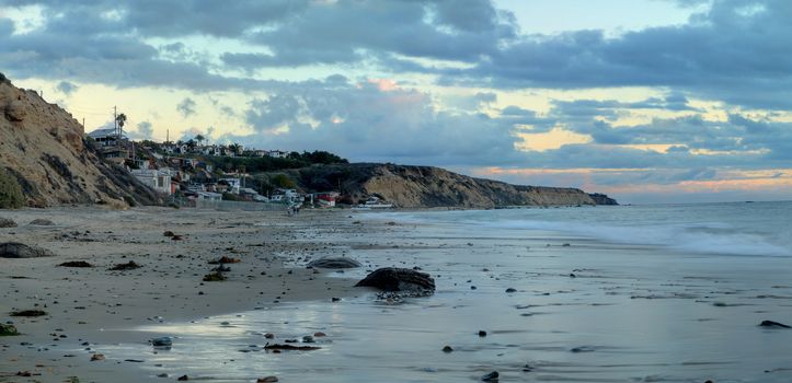 Cottages along Crystal Cove Beach, on the Newport Beach and Laguna Beach line in Southern California at sunset with a rainstorm looming.