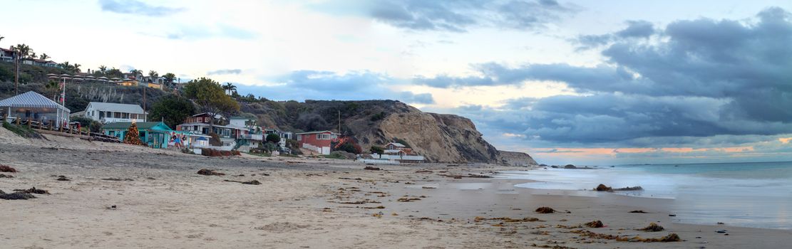 Cottages along Crystal Cove Beach, on the Newport Beach and Laguna Beach line in Southern California at sunset with a rainstorm looming.