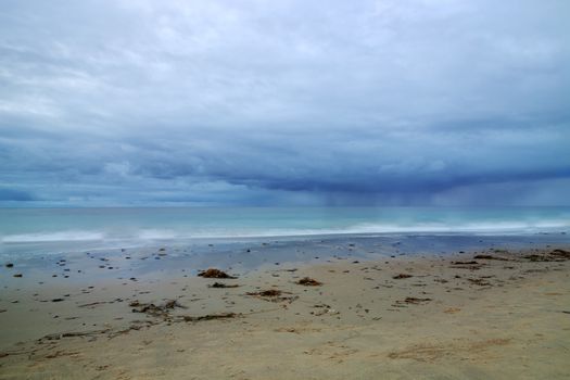 Rain clouds approach Crystal Cove Beach from the ocean, on the Newport Beach and Laguna Beach line in Southern California at sunset