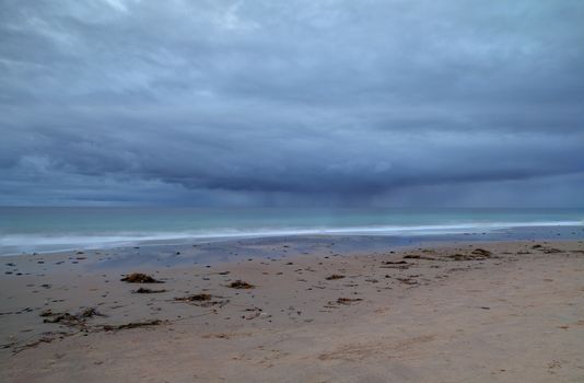 Rain clouds approach Crystal Cove Beach from the ocean, on the Newport Beach and Laguna Beach line in Southern California at sunset