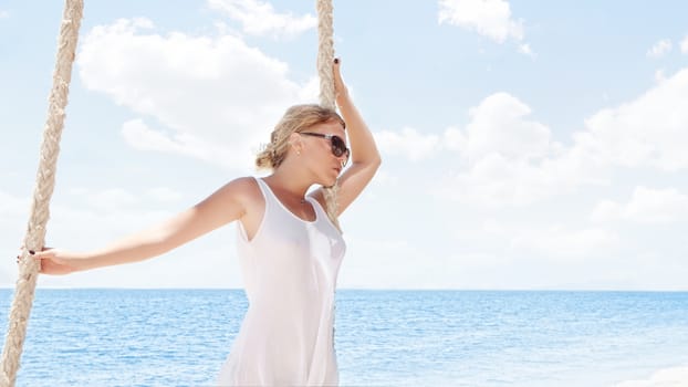 View of nice tropical  beach  with  girl on swing