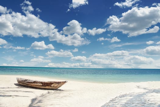 View of nice tropical  beach  with old boat and  some palm's shadows  around