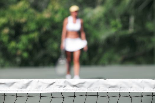 close up view of tennis net with player on the back. focused on the net