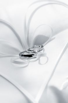 close up view of two wedding rings on white back