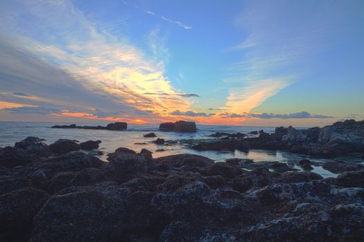 Long exposure of sunset over rocks, giving a mist like effect over ocean in Laguna Beach, California, United States