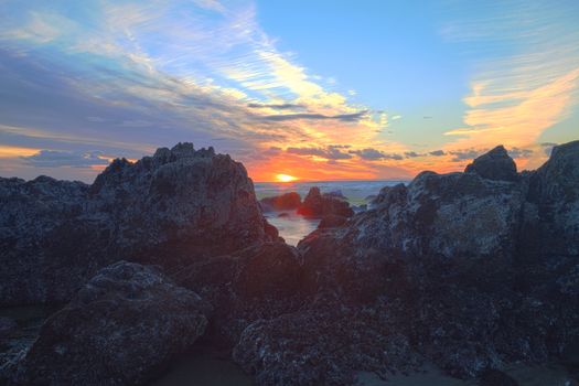 Long exposure of sunset over rocks, giving a mist like effect over ocean in Laguna Beach, California, United States