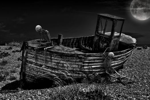 An old abandoned fishing boat stranded on a beech in black and white with two skeletons.