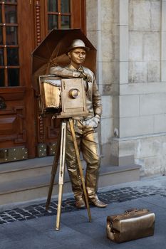 LVIV, UKRAINE - 06 OCTOBER 2013: unknown person in suit of photographer like in last century attracts tourists on city street Lviv in Ukraine.