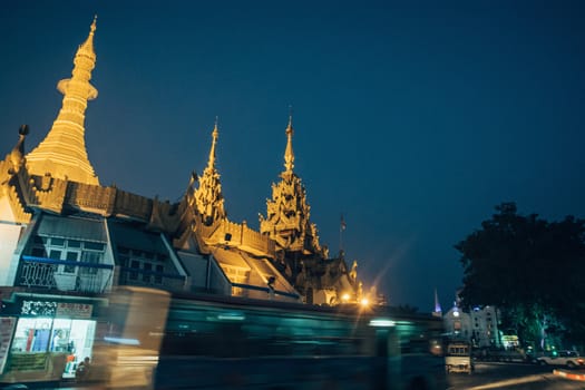 Sule Pagoda located in the heart of Yangon, Myanmar, Burma. Traffic is shown moving with blur to show action.