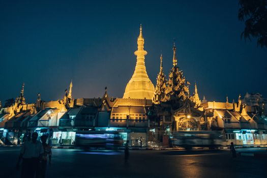 Sule Pagoda located in the heart of Yangon, Myanmar, Burma. Traffic is shown moving with blur to show action.