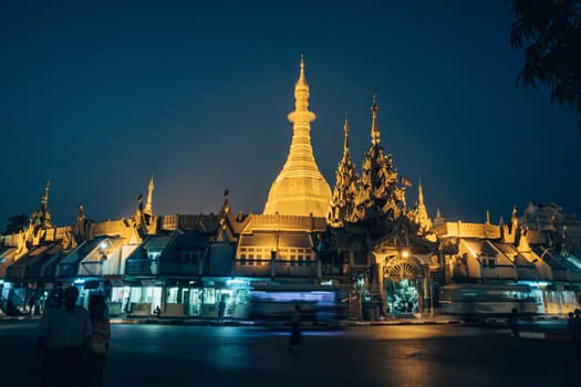 Sule Pagoda located in the heart of Yangon, Myanmar, Burma. Traffic is shown moving with blur to show action.