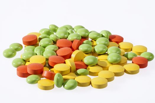 heap of colorful medical pills on white background