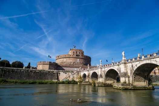 ROME, ITALY - SEPTEMBER 23, 2015 : Vıew of Castel Sant'Angelo, Castle of the Holy Angel built by Hadrian in Rome, along Tiber River on bright blue sky background.