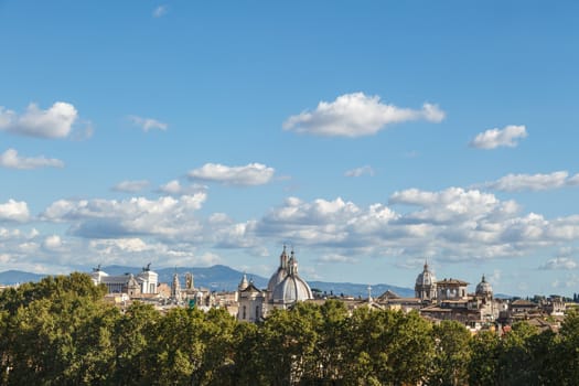 Top view of historical city of Rome with domes, on cloudy blue sky background.