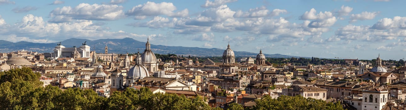 Top view of historical city of Rome with domes, on cloudy blue sky background.