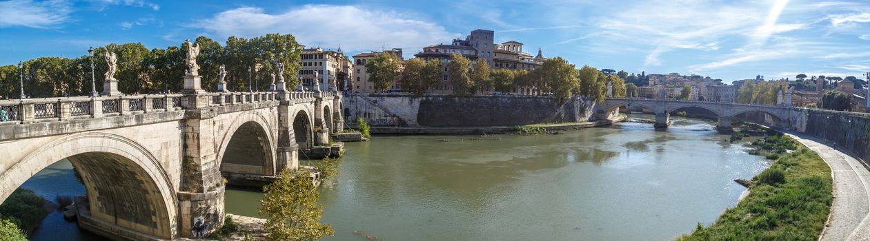 View of Ponte Sant'Angelo in front of Castle of the Holy Angel on Tiber River, on cloudy blue sky background.