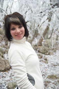 Pretty winter girl in the snow forest