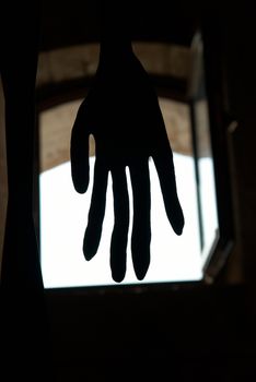 Black hand in front of the window