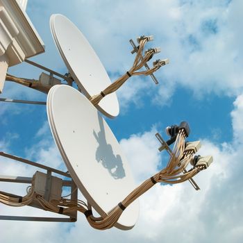 Satellite antenna on the wall with blue sky