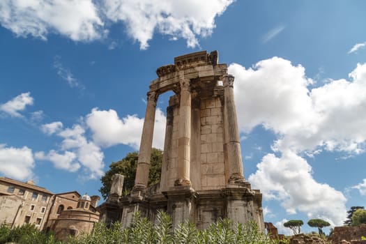 View of archeological area of ancient Roman Forum in Rome, on cloudy blue sky background.
