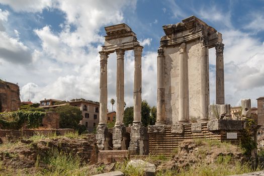 View of archeological area of ancient Roman Forum in Rome, on cloudy blue sky background.