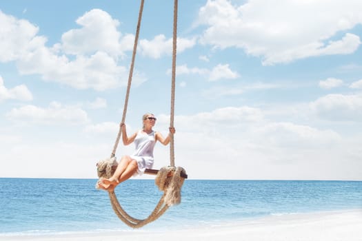 View of nice tropical  beach  with  girl on swing