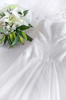 close up view of nice white wedding dress and flowers on white back