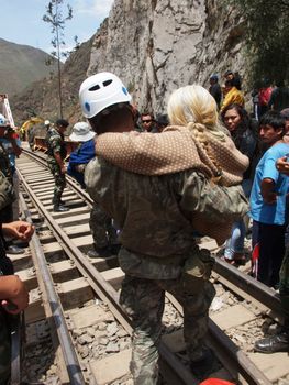 PERU, San Miguel de Viso: A soldier carries a victim after a mudslide on February 28, 2016 in San Miguel de Viso, at 80 kilometers eastern of Lima. Heavy rains have caused a series of mudslides that destroyed several sections of roads near Lima. 